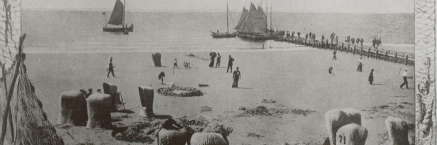 Strandkörbe am Wasser mit Brücke