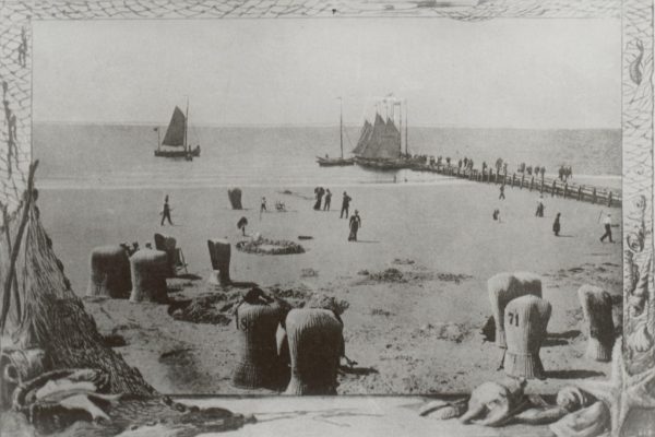 Strandkörbe am Wasser mit Brücke